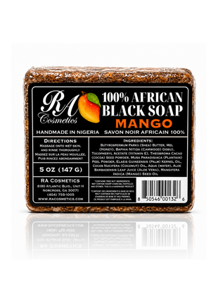 A rectangular bar of RA Cosmetics 100% African Black Soap in Mango scent, featuring a black label with white and orange text and a mango graphic, set against a white background with a reflection below.